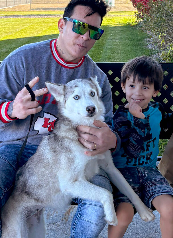 a father and son adopting a husky