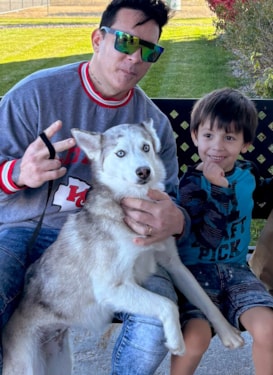 a father and son adopting a husky