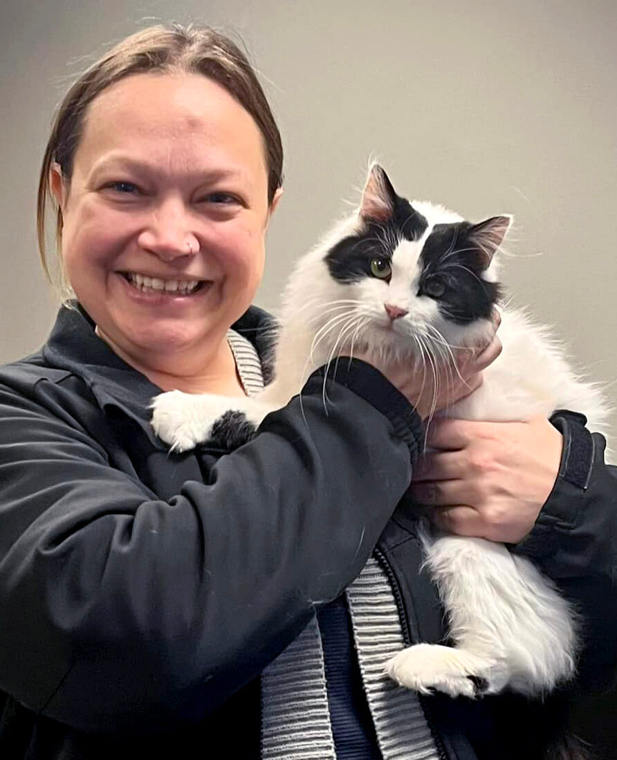 a woman adopting a black & white cat
