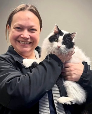 a woman adopting a black & white cat